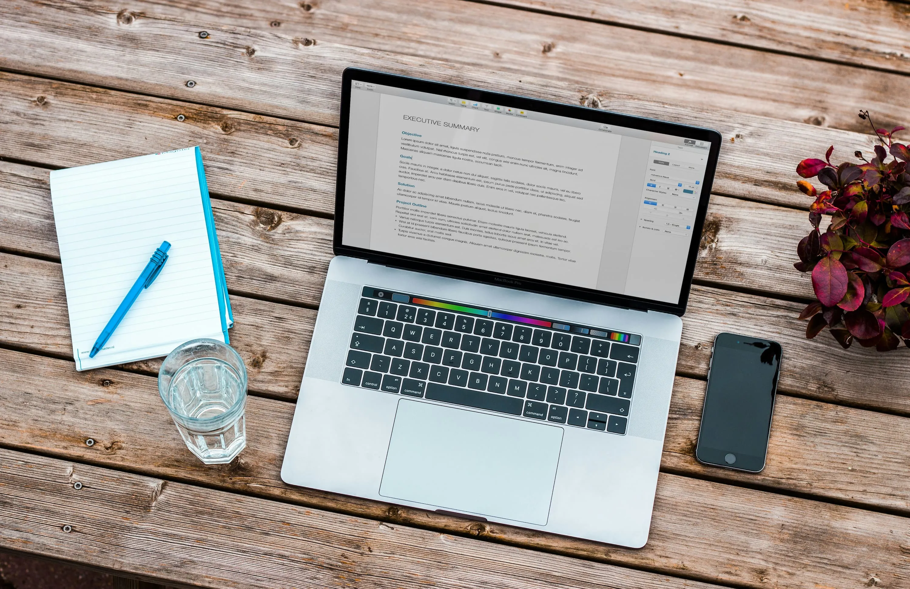 木製テーブルの上にMacBookが載っている画像
