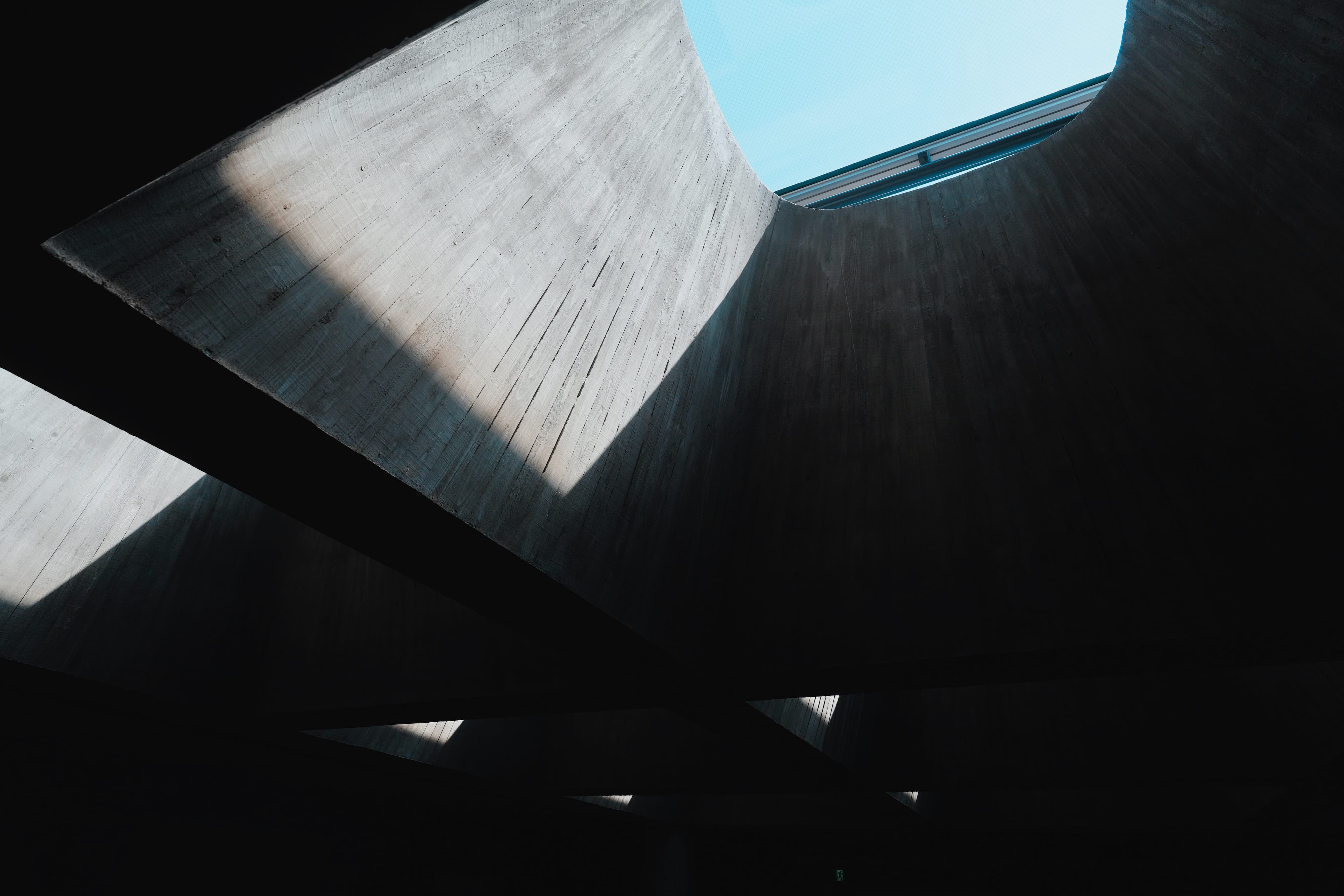 コンクリート建築の吹き抜けを見上げた、光と影のコントラスト。